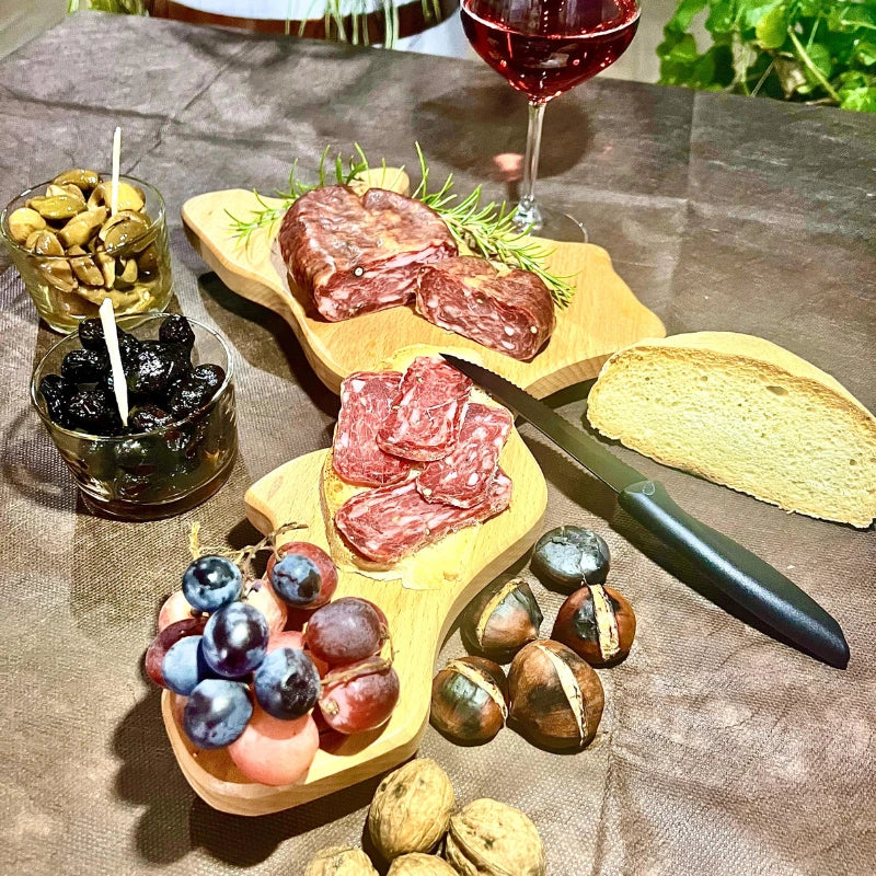 Immagine di Soppressata dolce calabrese Faanfood, affettata e servita in un aperitivo tipico. Presentata con contorni locali, la soppressata dolce è realizzata artigianalmente con ingredienti di qualità e senza conservanti, perfetta per accompagnare formaggi e vini della tradizione italiana.