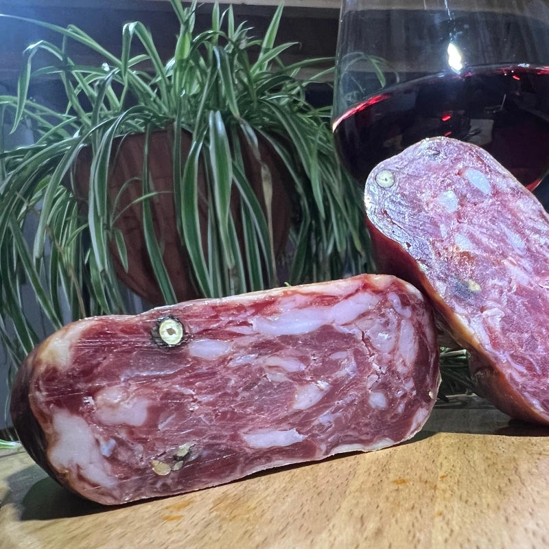 Immagine di Soppressata dolce calabrese Faanfood, tagliata in due pezzi per evidenziare la qualità degli ingredienti genuini. Prodotta artigianalmente senza conservanti, la soppressata dolce è realizzata con carne di maiale di prima scelta, offrendo un sapore autentico e tradizionale della Calabria.